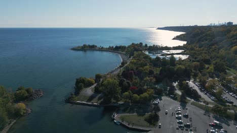 drone shot of a park that looks like an island with boats near a forest on a clear sunny day