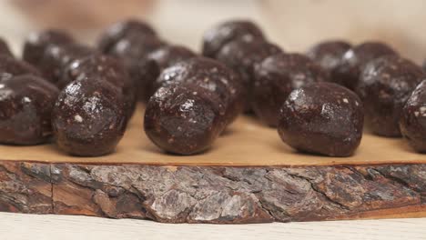 left to the right shot of the amazingly tasty round chocolate candies. woman's hand placing a just made candy onto the board. homemade sweets recipe demonstration video
