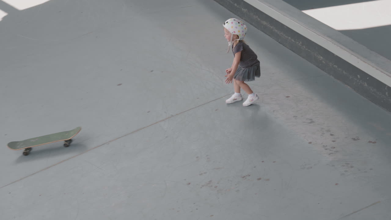 niña con patineta en un parque de patinaje cubierto
