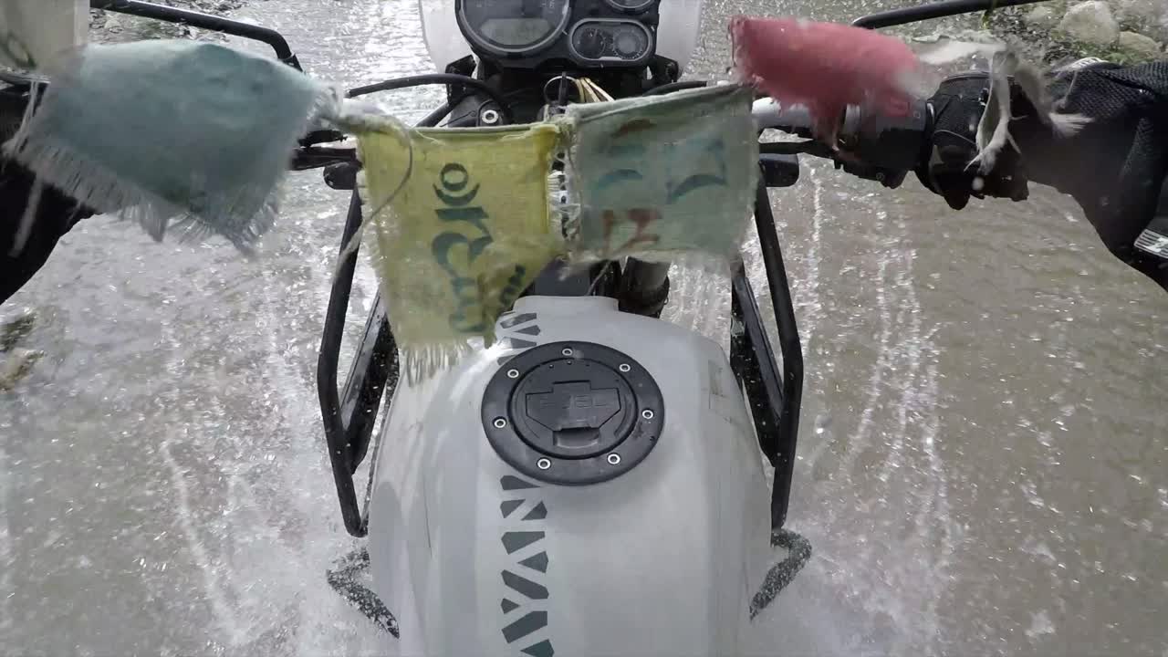 Driving on a motorbike through puddles and water with splashing of the camera lens