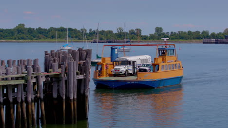 orange roll-on, roll-off ferry leaving the prison dock at hart island, with white prison bus