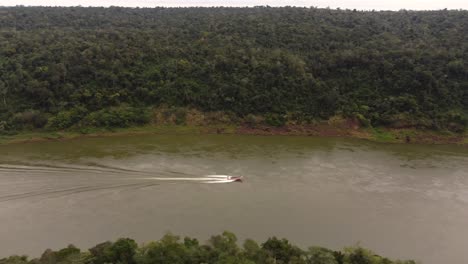isolated tourist boat sailing along navigable iguazu river at border between argentina and brazil