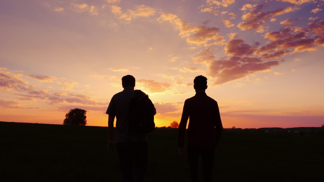 padre e hijo caminan por el campo al atardecer