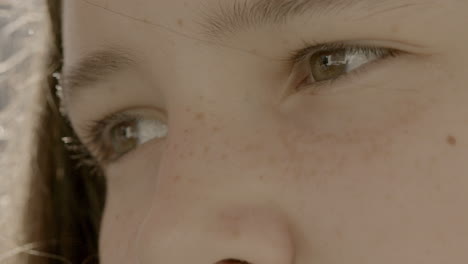 closeup on brown eyes of cute young girl staring off camera