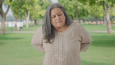 Sick-Indian-old-woman-suffering-from-back-pain-in-park