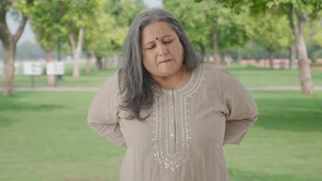 anciana india enferma que sufre de dolor de espalda en el parque