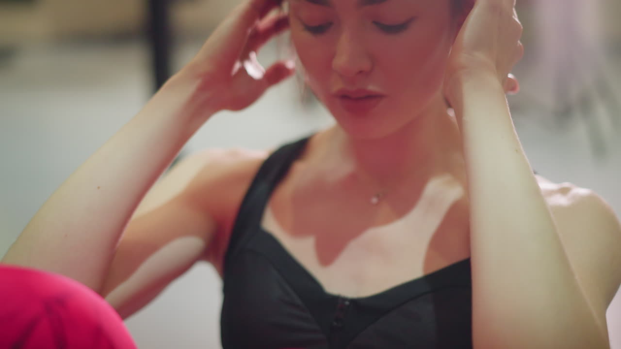 Donna asiatica esegue intensi crunch per gli addominali sul tappetino, con respirazione costante, pantaloni da allenamento rossi, sfondo da studio, espressione facciale concentrata, primo piano dell'impegno addominale e della perseveranza nell'allenamento.