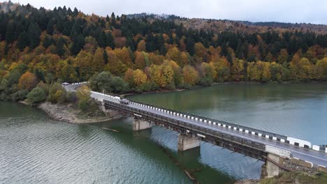 Drone-view-of-lake-and-car-passing-highway-in-Kakheti-region,-Georgia