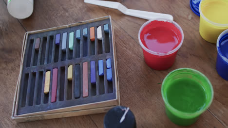 close up of paints and brushes on table in studio, slow motion