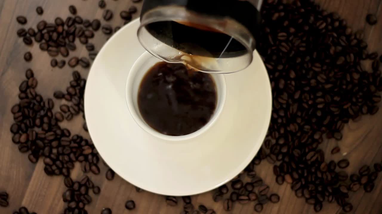 hot coffee pouring from glass coffee jug into a cup on a table top stock video