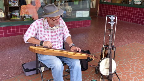 man street performer playing music on sidewalk