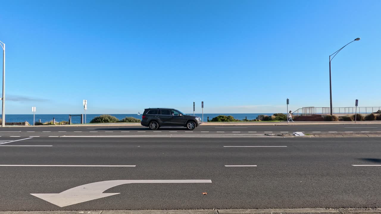 한 자동차가 해안 도로를 따라 이동합니다.