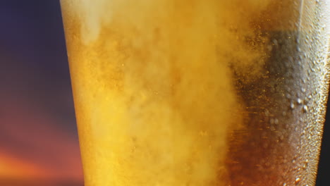 la cerveza se está vertiendo en un vaso angulado. ipa en el grifo. cerveza ligera fría en un vidrio con gotas de agua. cerveza artesanal formando olas de cerca. frescura y espuma. fondo de bar. cerveza artesanal de microbrewery.