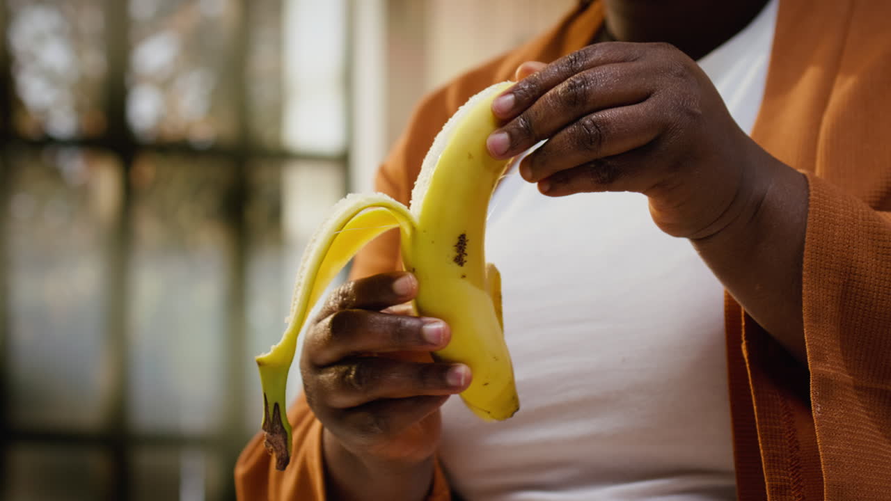 Content creator che sbuccia una banana e aggiunge fette su una ciotola di chia.