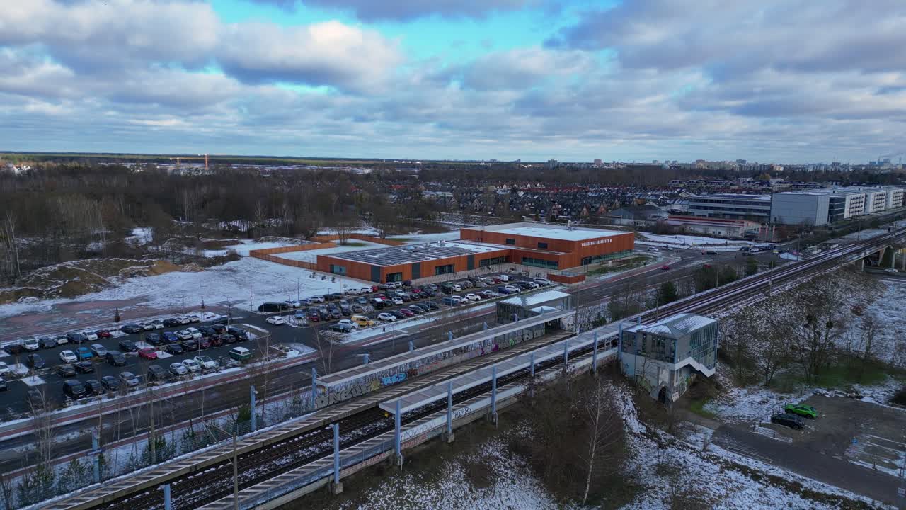 snowy train station with parked cars and surrounding buildings. Best aerial view flight drone shot footage from above