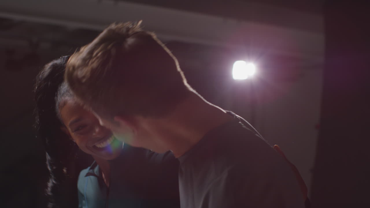 미소 짓는 운동 부부 나 친구 들 이 피트니스 의류 를 입고 체육관 에서 낮은 조명 으로 훈련 하는 스튜디오 초상화