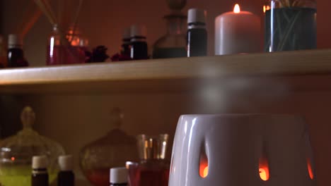 perfume making room with lots of candles flasks and glasses with colored liquids, near a steamer with steam coming out