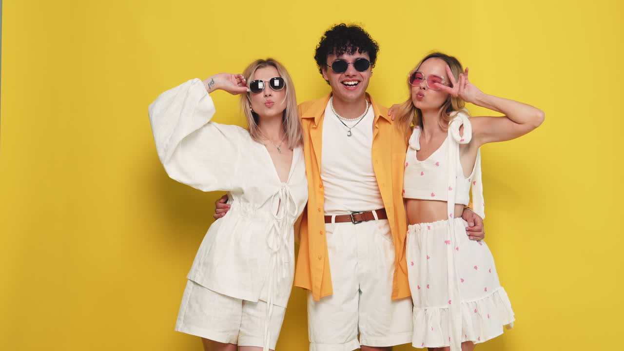 세 명의 친구들이 세련된 여름 의상을 입고 포즈를 취하고 있습니다.