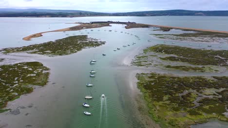 drone pull up over the sea as a boat sails into the distance