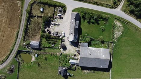 an animal farm in snedsted in denmark, filmed with a drone from above in perfect sunlight