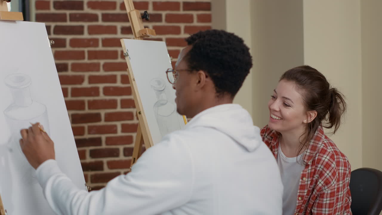 Man and woman attending art school class to draw vase model