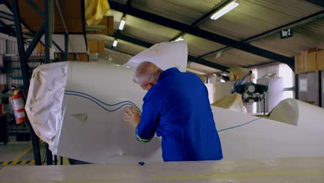 engineer marking a line on airplane parts 4k