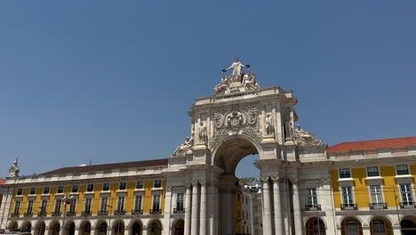 panning shot of arco da rua augusta triumphal arch at praca do comercio in lisbon during sunny day, portugal