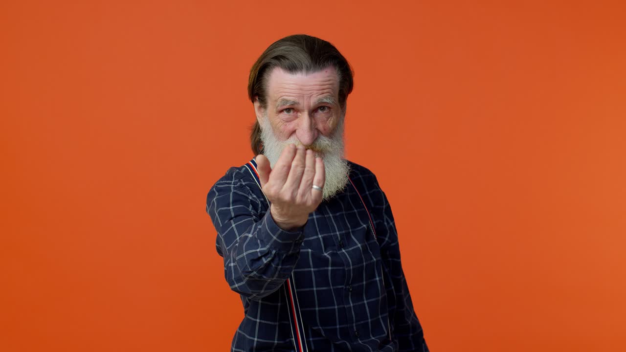 anciano señalando a la cámara con una expresión alegre lúdica, haciendo una elección, mostrando la dirección