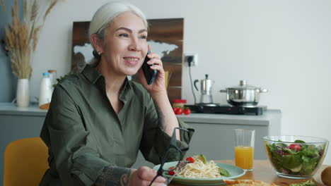 senior woman talking on phone during meal