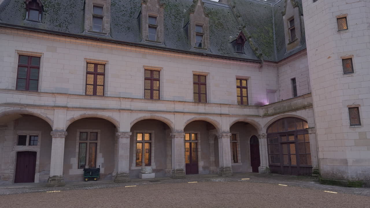 A stunning view of the courtyard of an old European castle at night