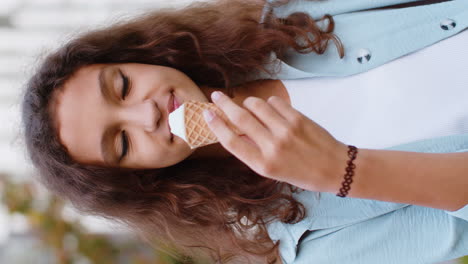 muy feliz preadolescente niña niña de pie, comiendo delicioso helado en taza de waffle en la ciudad urbana