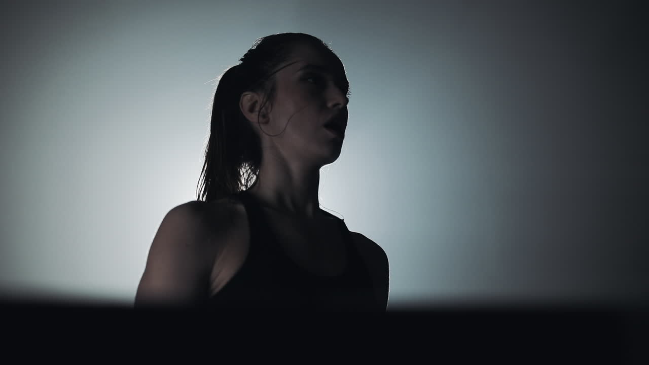 Determined Woman in Silhouette During Workout