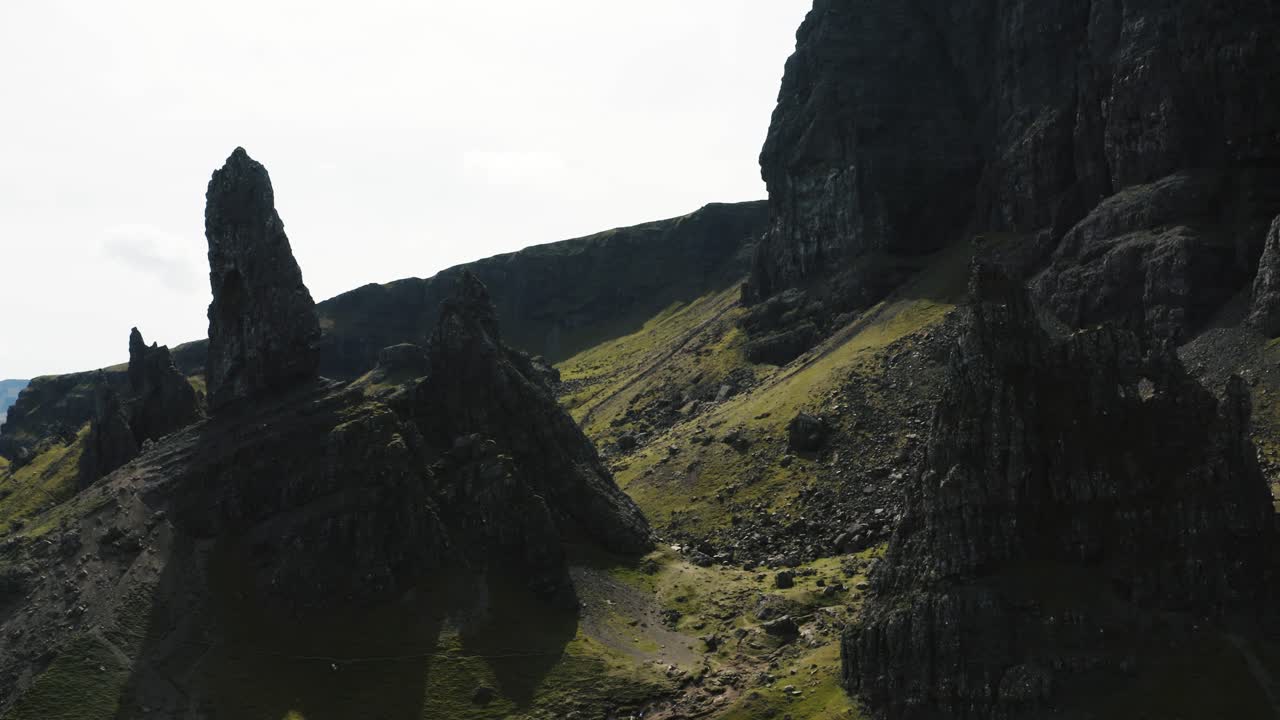 vista de drones pasando entre grandes rocas en el viejo hombre de storr en la isla de skye de escocia