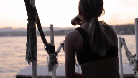 young cure latin girl drinking a beer near a lake during sunset chilling relaxing enjoying