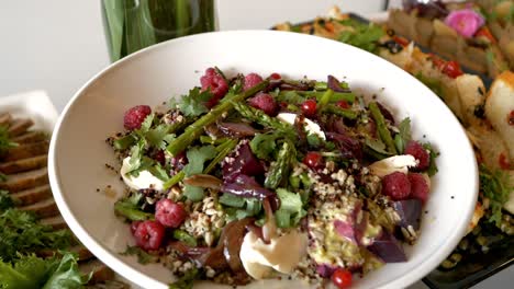 platter with a salad consisting of raspberries, asparagus, red currants, sunflower seeds, and pieces of beetroot