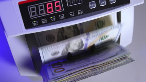 electronic operations for counting paper money. cash money counting machine. banknote counter are counting one hundred dollar bills. top view. close-up.
