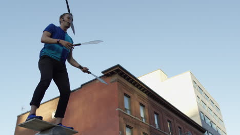 juggler in city using swords in slow motion