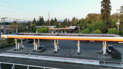 Drone-shot-of-a-slow-gas-station-near-sunset