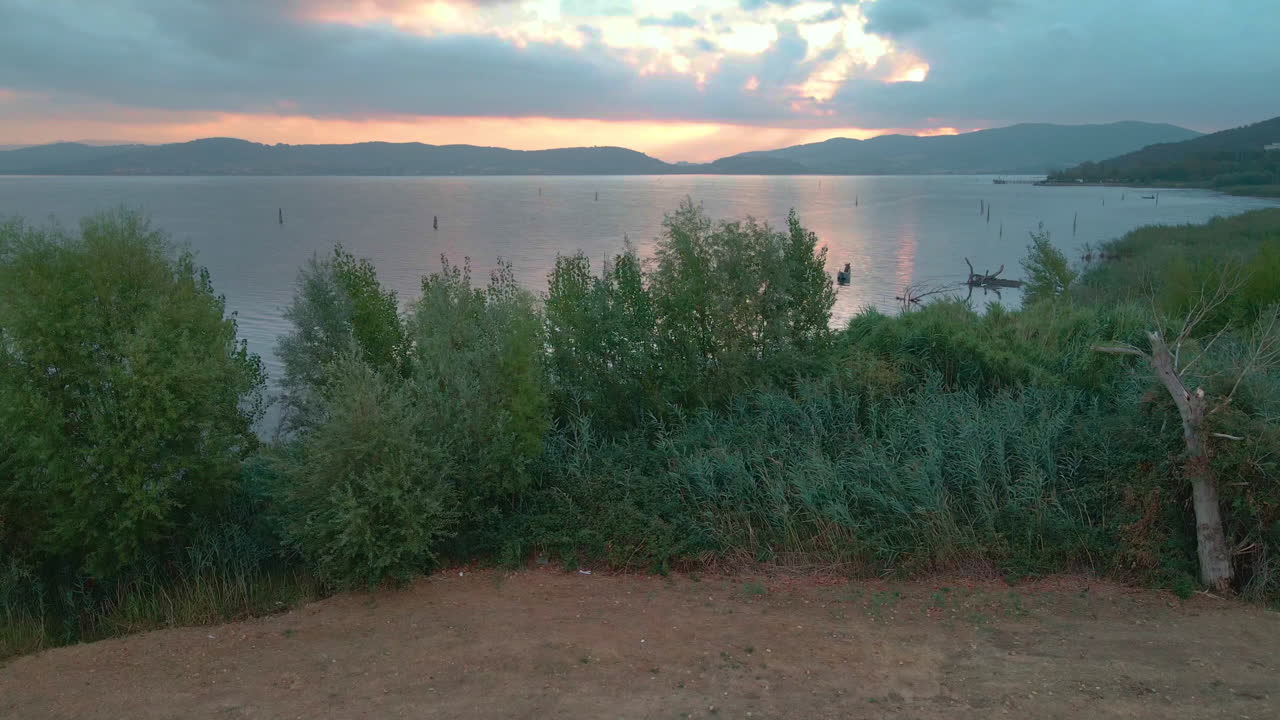 revelan una toma del lago trasimeno en umbría, italia durante el amanecer - drone ascendiendo