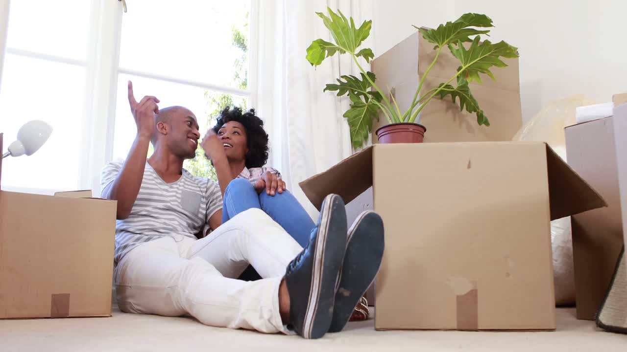 Smiling couple unpacking cardboard boxes