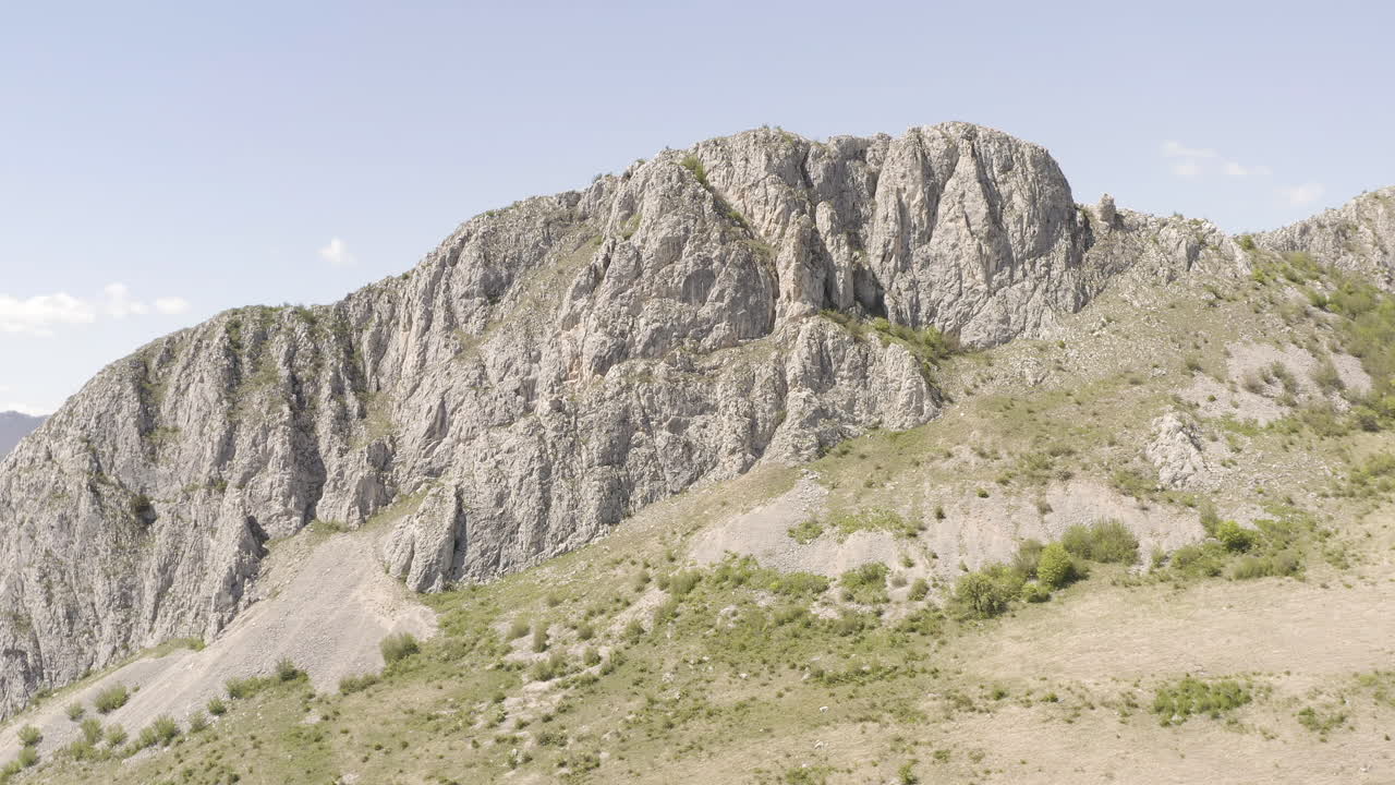 Panoramic View of a Massive Rocky Mountain Under a Clear Sky
