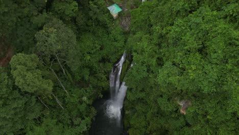 Una-Pintoresca-Cascada-Rodeada-De-árboles-Y-Cabañas-En-Bali,-Indonesia