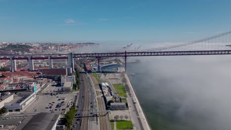 drone shot of the fog under the bridge in lisbon.