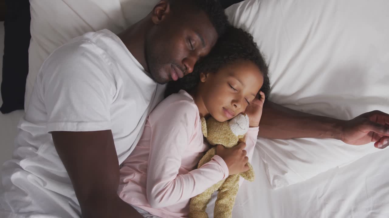 African american father and daughter sleeping together