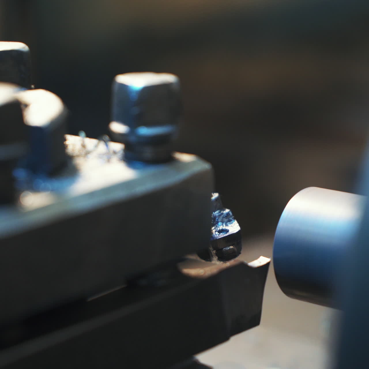 Metalworking industry: cutting steel metal shaft processing on lathe machine in workshop. Selective focus on tool
