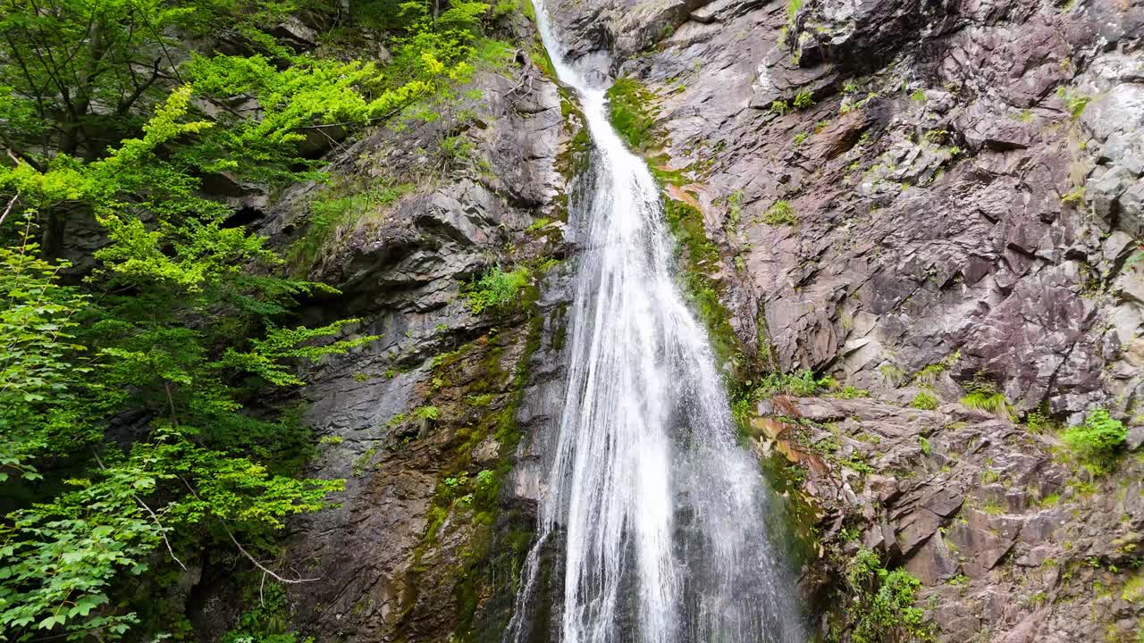 Aerial view of Sutovsky waterfall cascading through lush forest in Mala Fatra National Park, Slovakia. Majestic nature scene in Europe, perfect for travel, documentary, and environmental projects