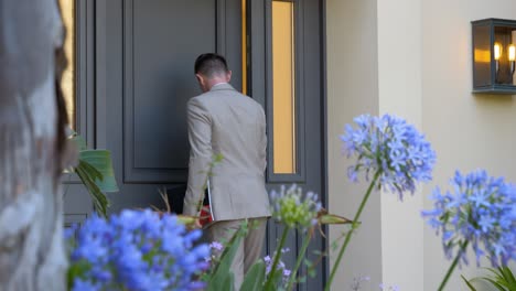 slow motion shot of male businessman entering luxury villa door - panning shot