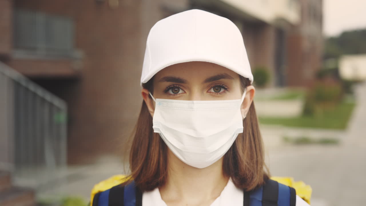 Woman wearing a mask and cap in the city