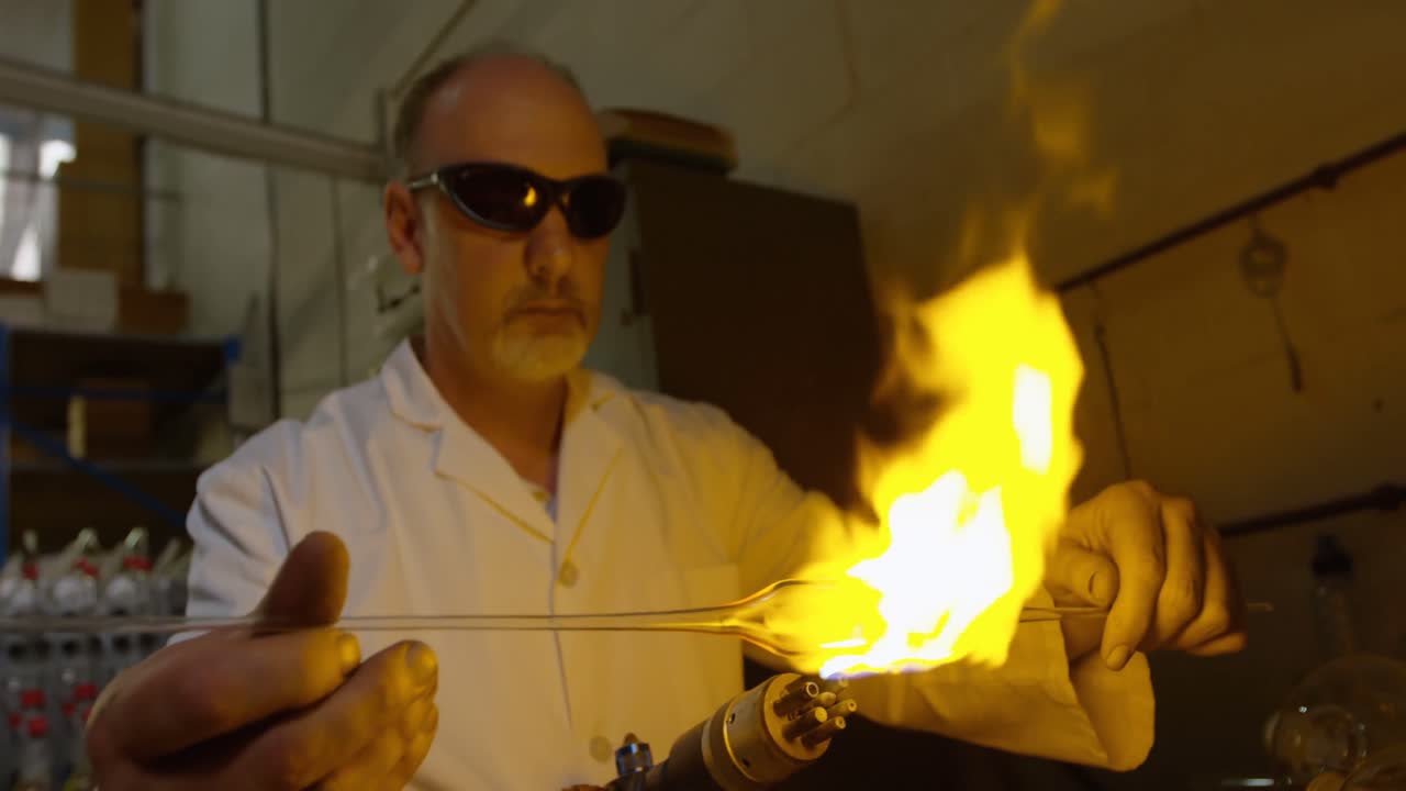 vista frontal de un trabajador masculino maduro creando vidrio en una fábrica de vidrio 4k