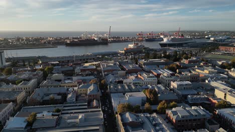 aerial flyover fremantle port with ship and industry during sunset time on perth city - establishing drone flight